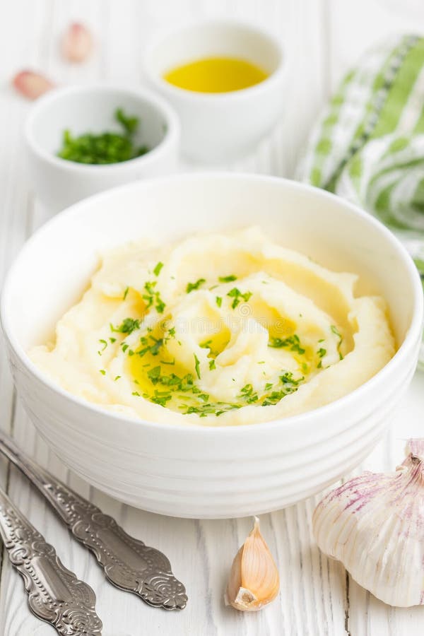 Batatas trituradas com salsa e azeite em uma bacia imagens de stock Batatas trituradas com salsa e azeite em uma bacia imagens de stock