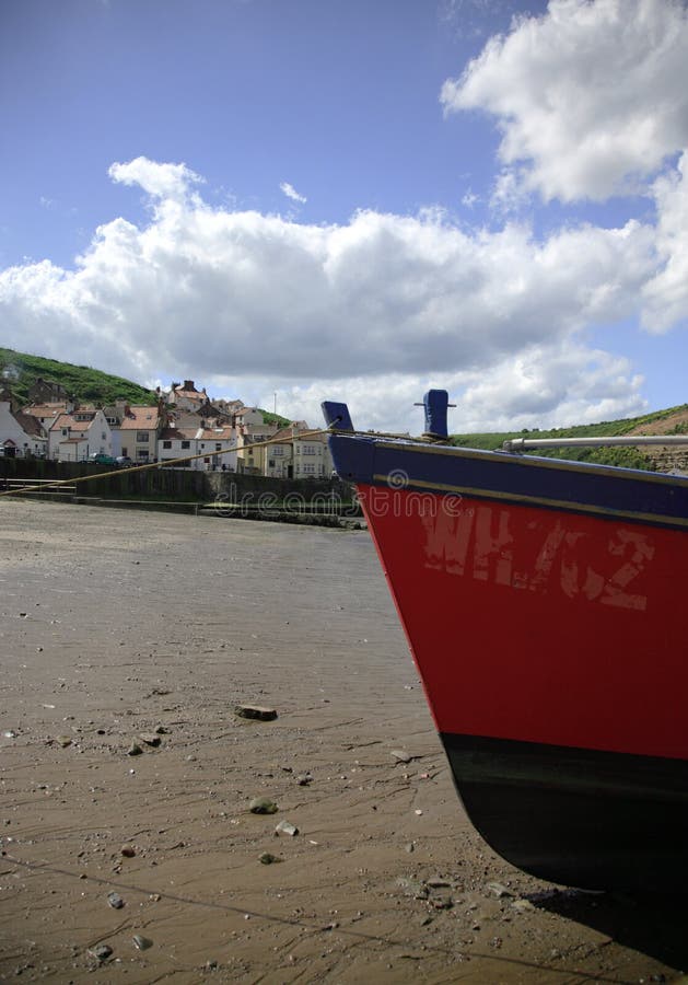 Bright red fishing boat moored on the beach. Bright red fishing boat moored on the beach