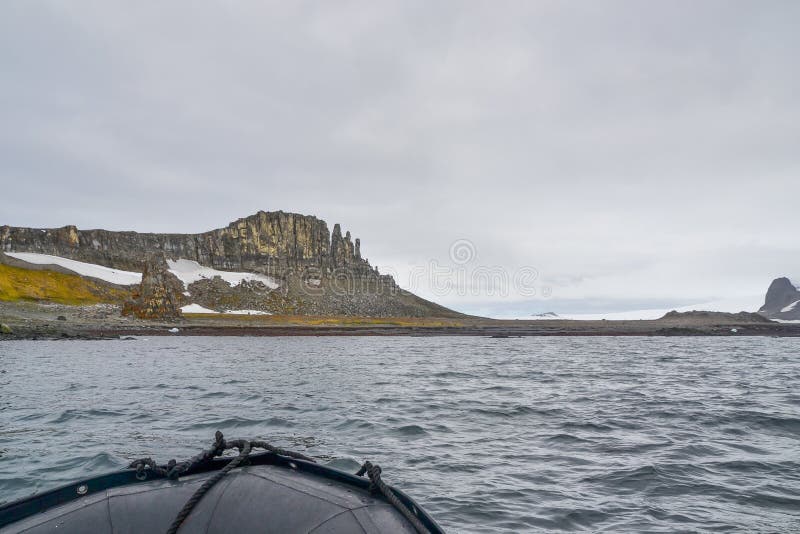 Bateau de zodiaque voyageant autour des montagnes rocheuses en Antarctique photos libres de droits Bateau de zodiaque voyageant autour des montagnes rocheuses en Antarctique photos libres de droits
