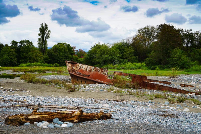 Bateau rouillé échoué à terre sur la plage avec des cailloux en Mer Noire images stock Bateau rouillé échoué à terre sur la plage avec des cailloux en Mer Noire images stock