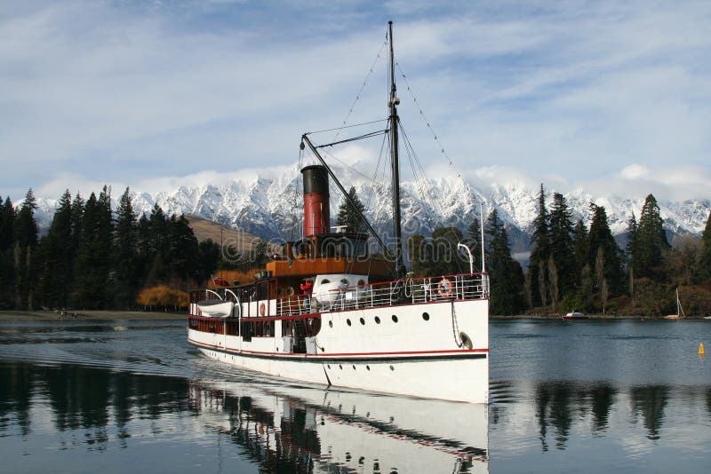 The TSS Earnslaw steamboat on Lake Wakatipu, Queesntown, New Zealand, with The Remarkables mountains in the background. The TSS Earnslaw steamboat on Lake Wakatipu, Queesntown, New Zealand, with The Remarkables mountains in the background