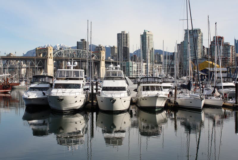 Yachts moored at Granville Island, Vancouver, British Columbia, Canada. The Vancouver skyline including the Burrard Street Bridge is seen in the background. Yachts moored at Granville Island, Vancouver, British Columbia, Canada. The Vancouver skyline including the Burrard Street Bridge is seen in the background.