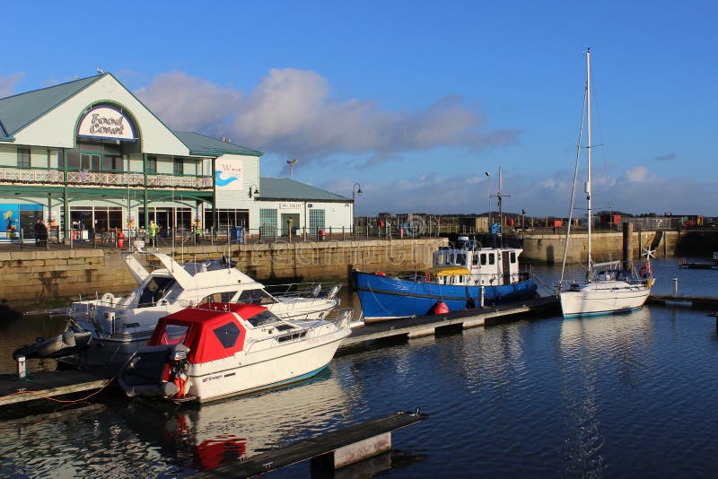 View from the Freeport shopping area at Fleetwood in Lancashire, England looking to motor boats and a yacht moored in the marina in the old Fleetwood dock. View from the Freeport shopping area at Fleetwood in Lancashire, England looking to motor boats and a yacht moored in the marina in the old Fleetwood dock.