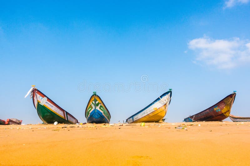Bateaux de pêche sur la plage de sable de marina à chennai avec ciel bleu et nuages blancs