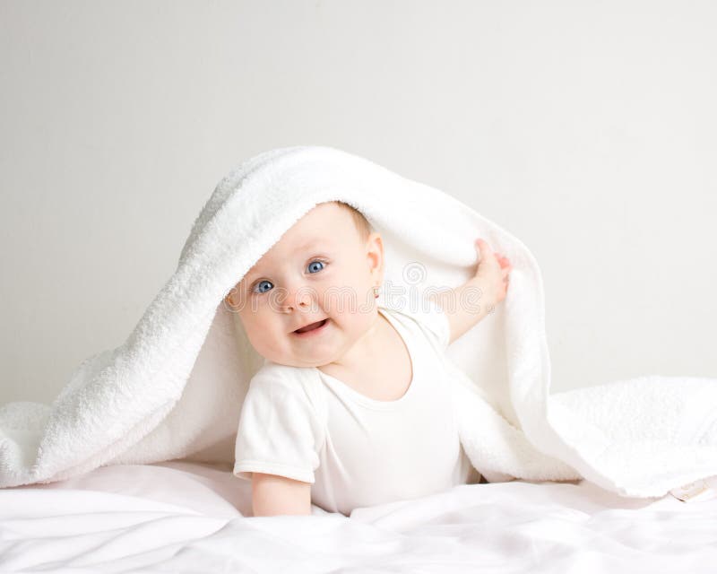 Kleines baby unter weißen Handtuch.
