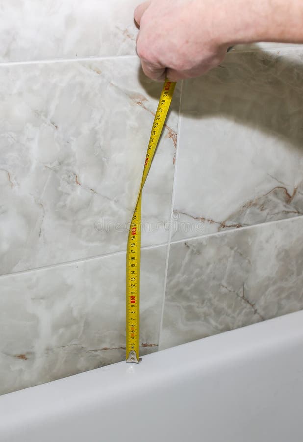 Bath Installation. Worker is Making Fastener with Measure Tape