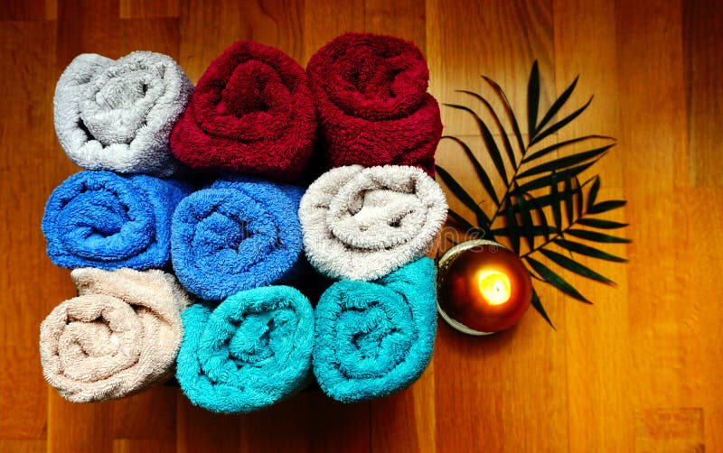 Bath or wellness accessories, soft terry colorful towels stacked in a box on the wooden background stock image