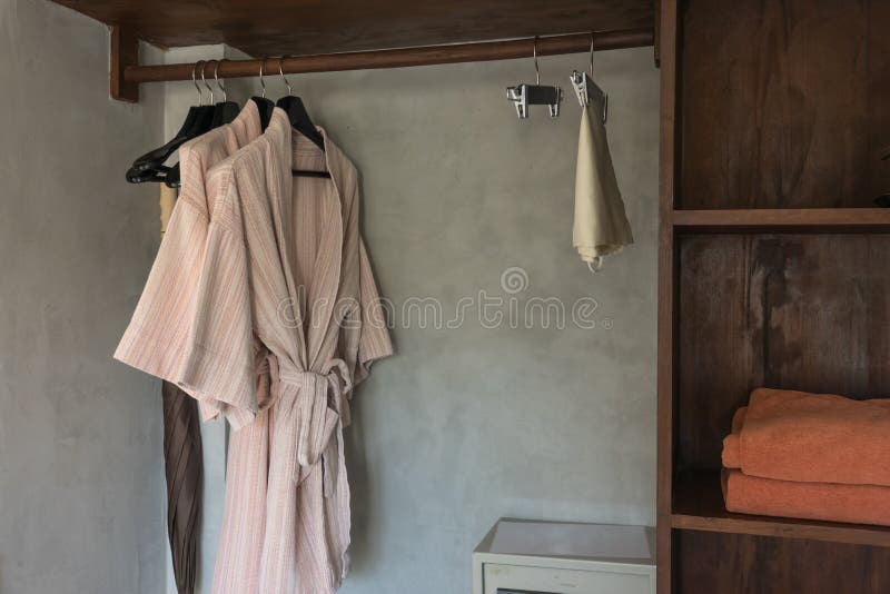 Bathrobe with Wooden Hangers in Wardrobe. Stock Image Image of towel