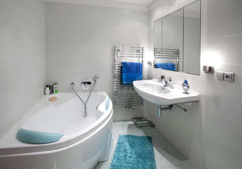 Biela moderná kúpeľňa s modrými doplnkami.