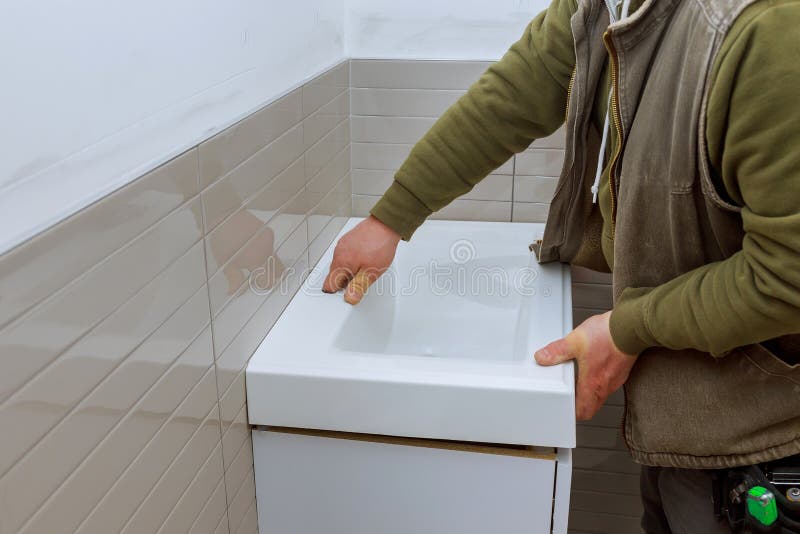 A bathroom remodel counter tap bathroom vanity cabinets to completion stock image A bathroom remodel counter tap bathroom vanity cabinets to completion stock image