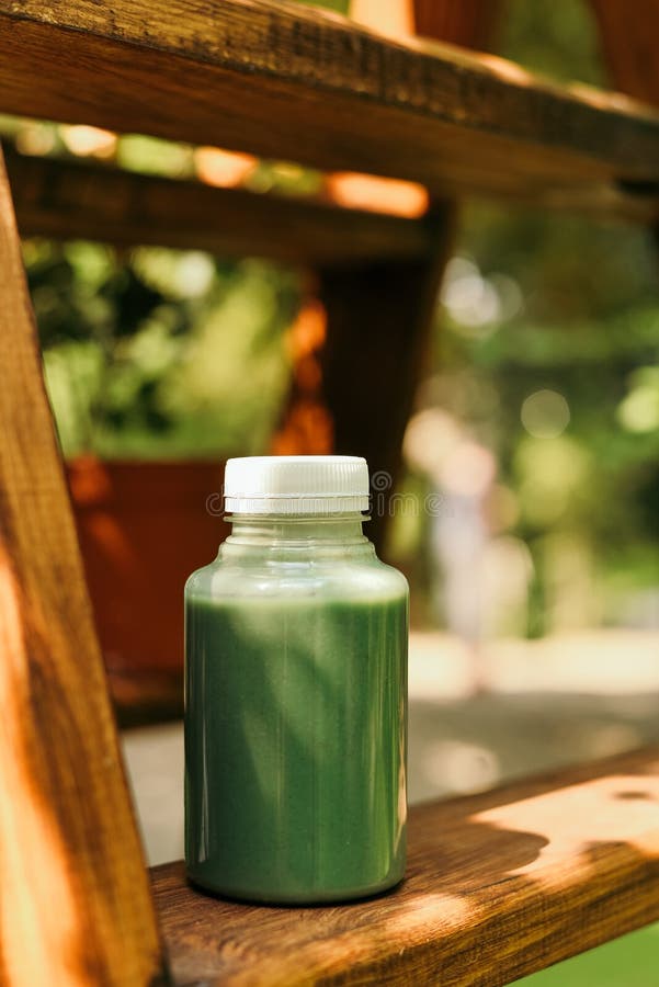 Batido da manga em um frasco e em uma manga de vidro de pedreiro em um fundo verde agita??o Conceito do fruto tropical imagens de stock Batido da manga em um frasco e em uma manga de vidro de pedreiro em um fundo verde agita??o Conceito do fruto tropical imagens de stock