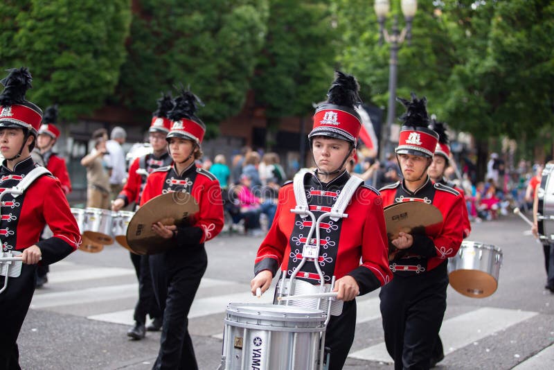 Portland, OR / USA - June 11 2016: Grand floral parade - Young drummer in red uniform walking with Yamaha drums as part of the marching band. Portland, OR / USA - June 11 2016: Grand floral parade - Young drummer in red uniform walking with Yamaha drums as part of the marching band.