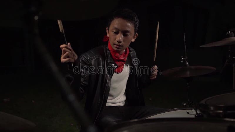 Batteur de rock adolescent un jeune garçon américain américain branché et talentueux jouant de la batterie dans une veste de cuir clips vidéos