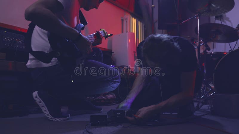 Batteur et guitariste relient les instruments aux enceintes et à l'amplificateur. banque de vidéos