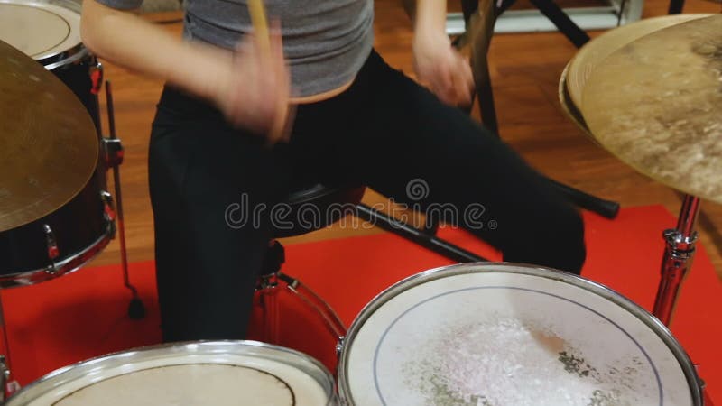 Batteur féminin avec ses compagnons de groupe pratiquant dans la chambre de répétition clips vidéos