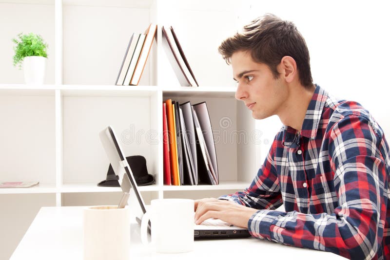 Battitura a macchina teenager sul computer fotografie stock libere da diritti Battitura a macchina teenager sul computer fotografie stock libere da diritti