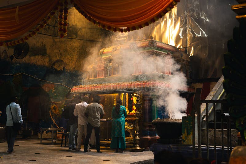 Batu Caves Malaysia 18 gennaio 2025 : All'interno del Batu Caves la gente si trova vicino a un santuario indù avvolto dal fumo di fotografia stock libera da diritti