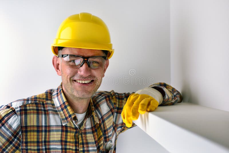 Bauarbeiter, der gelben Sturzhelm und das Lächeln trägt lizenzfreie stockfotografie Bauarbeiter, der gelben Sturzhelm und das Lächeln trägt lizenzfreie stockfotografie
