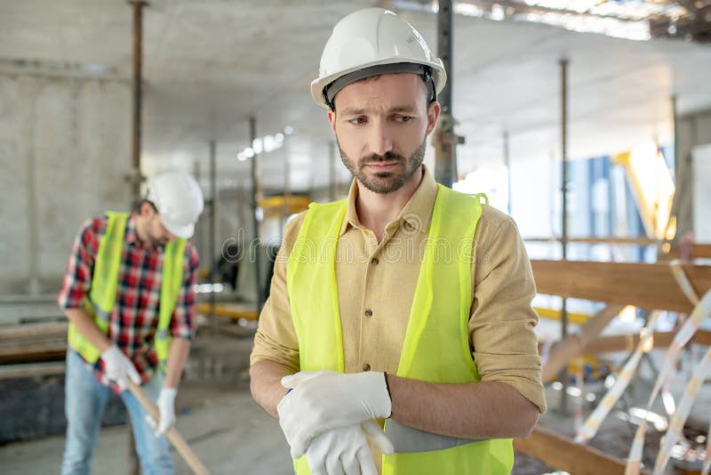 Bauarbeiter in Der Gelben Weste Und in Den Handschuhen, Die Den