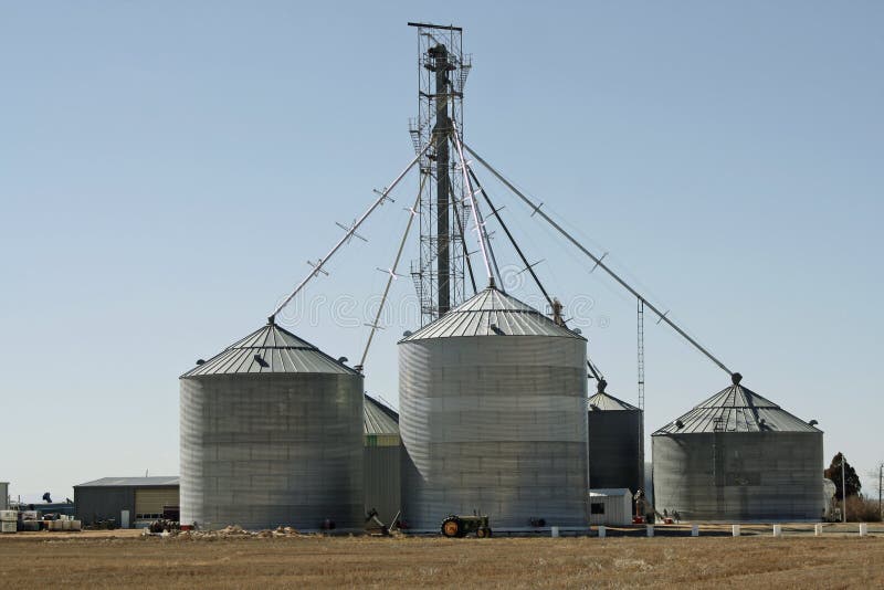 A tractor stands in front of grain silos on a Colorado farm. The silos can be used for different types of grains and corn. A tractor stands in front of grain silos on a Colorado farm. The silos can be used for different types of grains and corn.