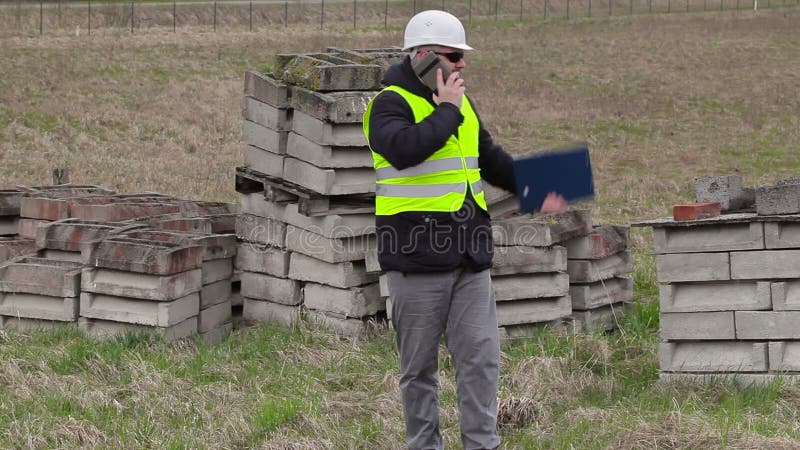 Bauingenieur mit intelligentem Telefon am Platz, in dem Neubaustandort werden Sie stock footage