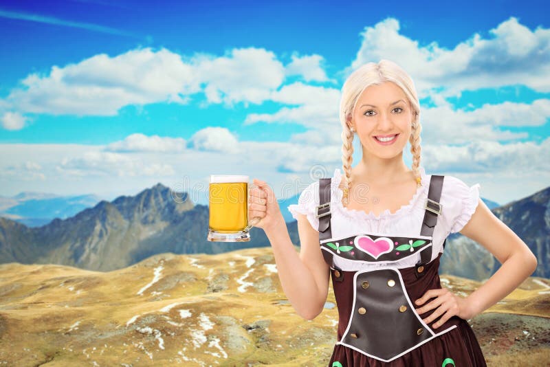 Bavarian woman holding a beer high in the mountains stock photography Bavarian woman holding a beer high in the mountains stock photography