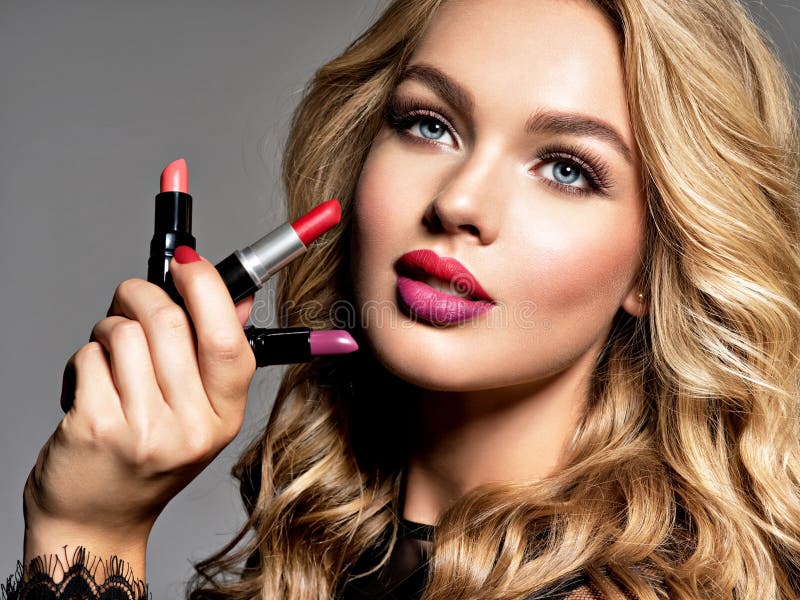 BBeautiful woman holds lipsticks. Makeup. Beauty concept