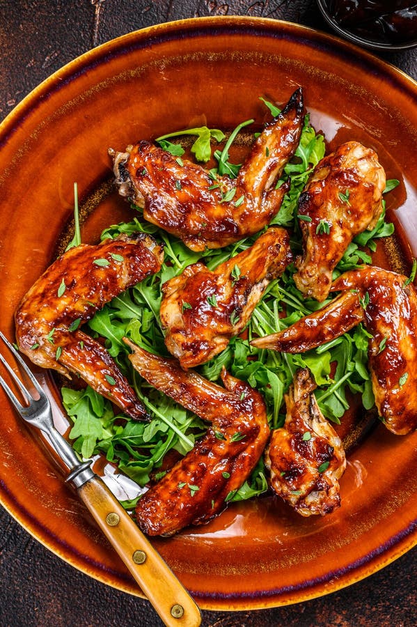 Bbq Buffalo Chicken Wings on a Plate with Arugula. Dark Background