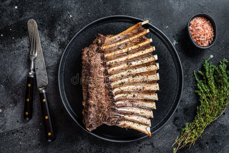 BBQ Grilled Rack of Lamb Mutton Ribs Chops on Plate with Thyme. Black