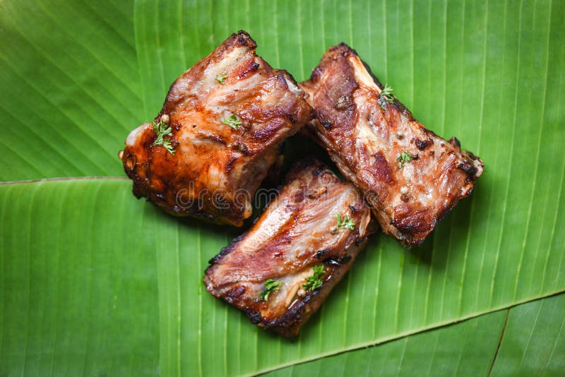 Bbq pork ribs grilled with herbs spices served on banana leaf - Roasted barbecue pork spare rib sliced royalty free stock photo Bbq pork ribs grilled with herbs spices served on banana leaf - Roasted barbecue pork spare rib sliced royalty free stock photo