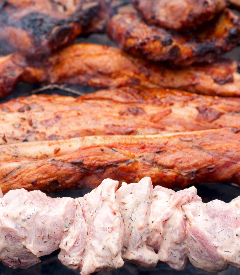 Bbq ribs and bacon on a grill with charcoal