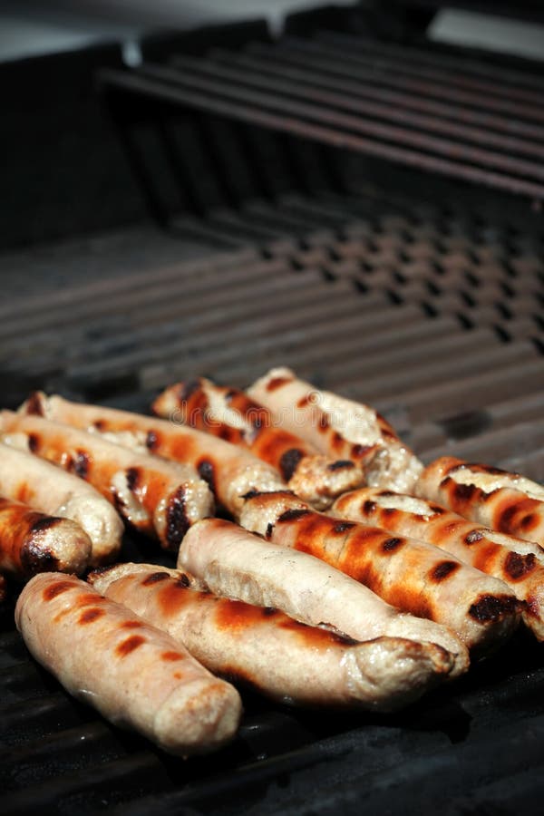 Four Sausages Called Bratwurst, Grilling Over Hot Coals on a BBQ Stock