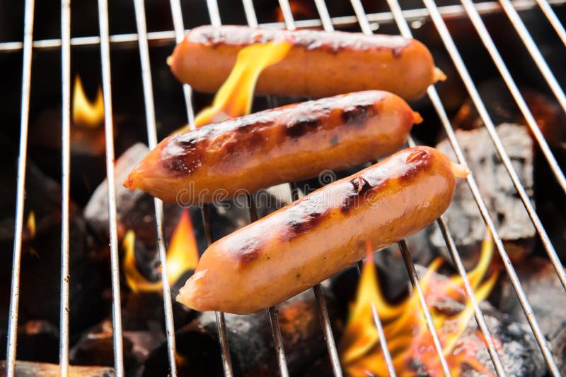 Grilled Smoked Sausages and Meatballs Outdoors. Meat Baked on the Grill