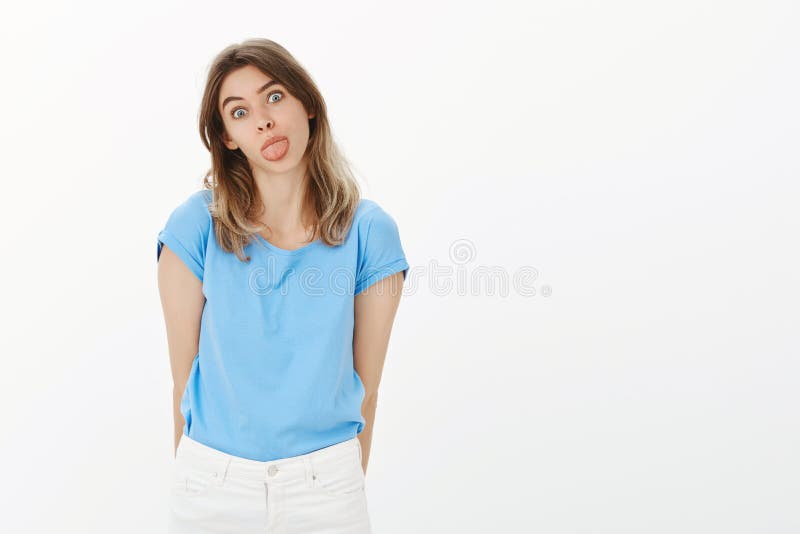 Be on bright side. Portrait of playful childish adult woman with fair hair, sticking out tongue, making funny face and royalty free stock photos Be on bright side. Portrait of playful childish adult woman with fair hair, sticking out tongue, making funny face and royalty free stock photos