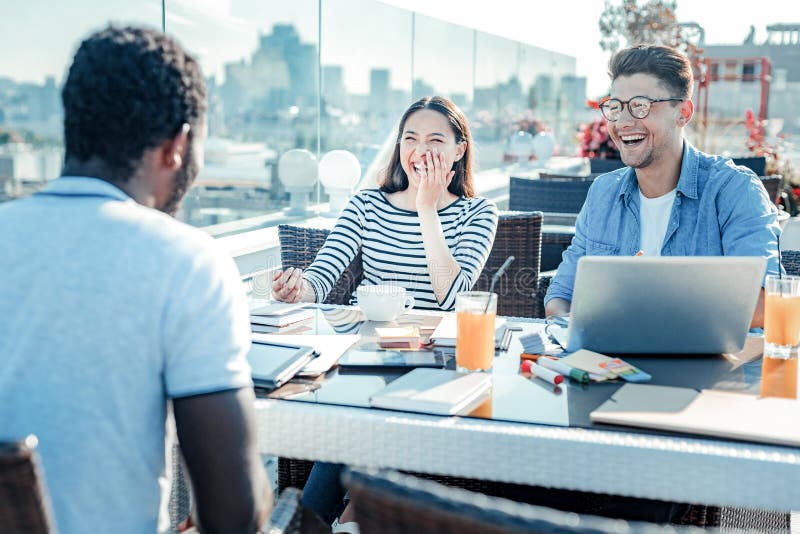 Joyful female person laughing at funny joke