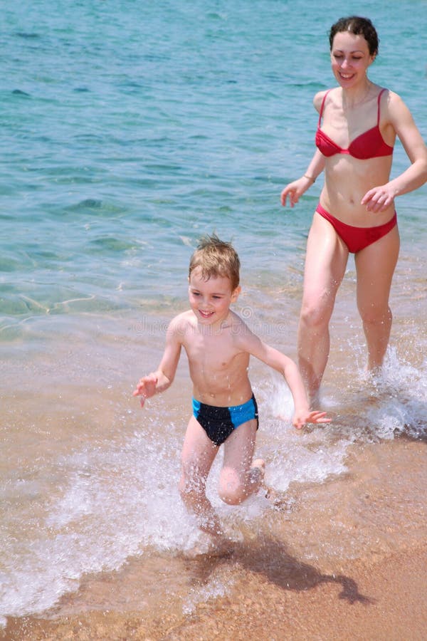 On a beach. Mother and child run on a beach On a beach. Mother and child run on a beach