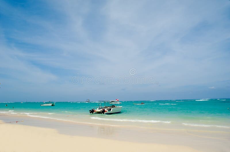 Exotic beach with white sand. In the water you can see some boats. Dominican Republic, Punta Cana. Exotic beach with white sand. In the water you can see some boats. Dominican Republic, Punta Cana.