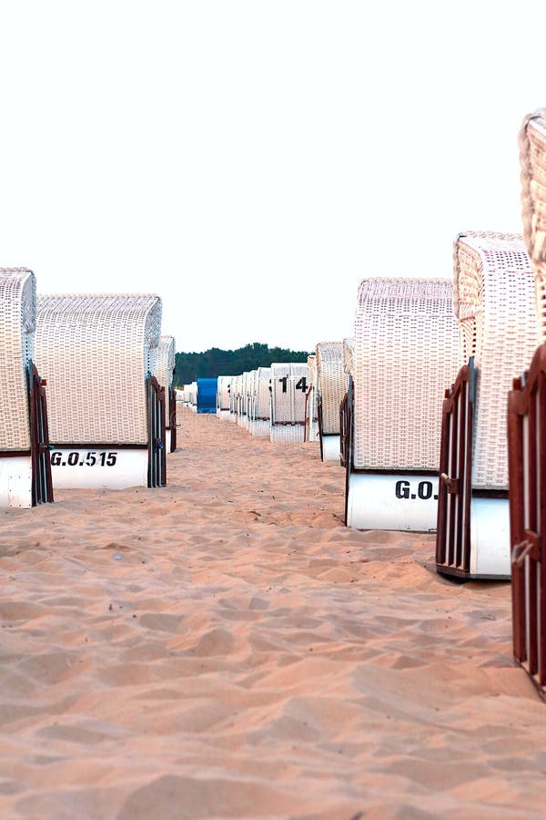 Beach chairs at the Baltic Sea, many white and one blue, vertical royalty free stock images Beach chairs at the Baltic Sea, many white and one blue, vertical royalty free stock images