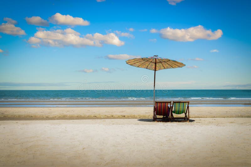 Beach Chairs On The Sand Beach With Cloudy Blue Sky Background. Stock