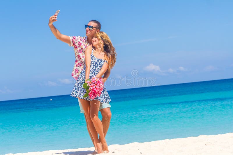 Beach couple on romantic travel honeymoon vacation summer