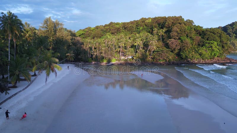 Beach evening atmosphere, swing on palm tree. Great aerial top view flight drone