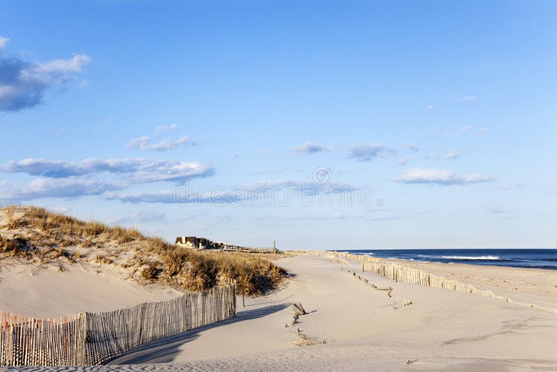 Beach Fence, Sand, Houses and the Ocean.