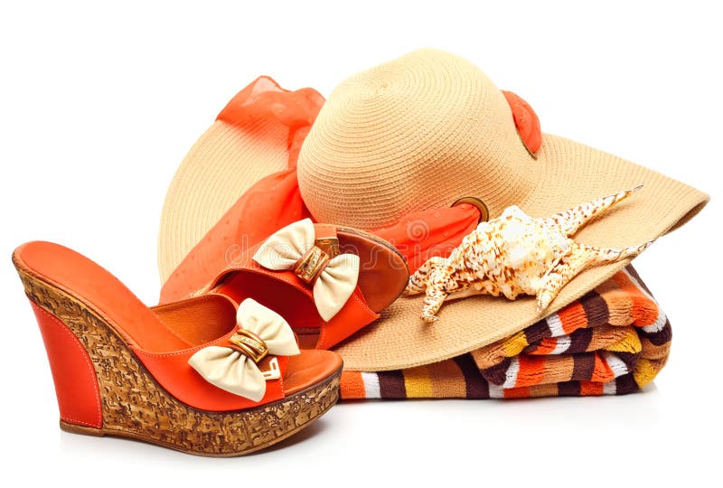 Beach hat, towel, woman shoes and a seashell