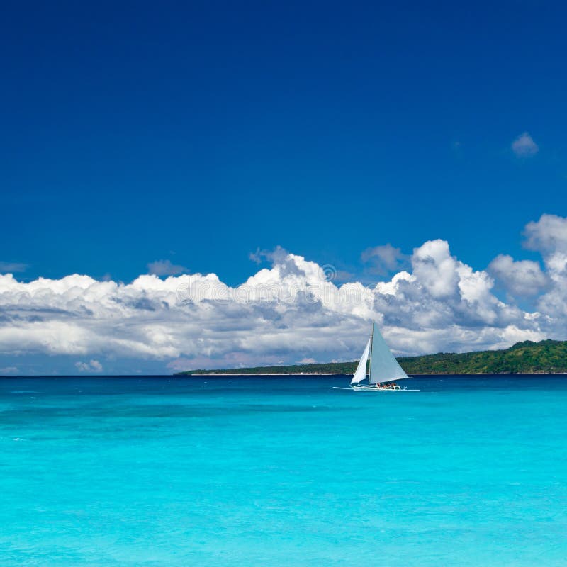 Beach with sailboat in ocean