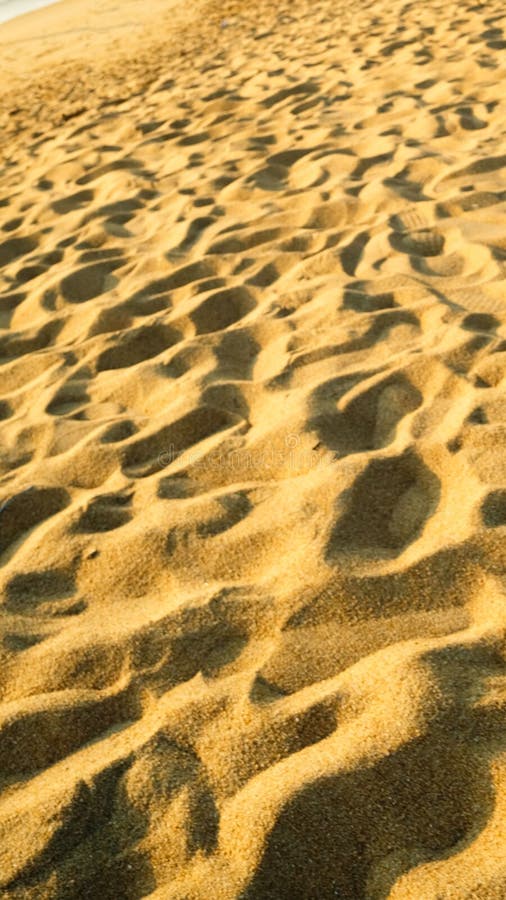 A beach scene with sand and footprints stock images