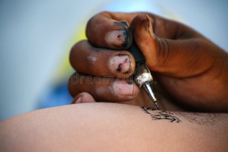 Špinavé ruky v procese čerpania dočasné a povrchné atrament tetovanie na pláži v Mexiku