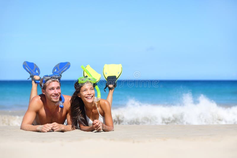 Beach travel couple having fun snorkeling looking