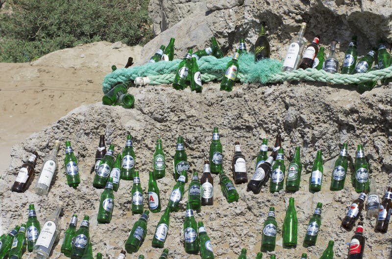 Beautifully laid out empty beer bottles on a huge boulder in a sunny weather.