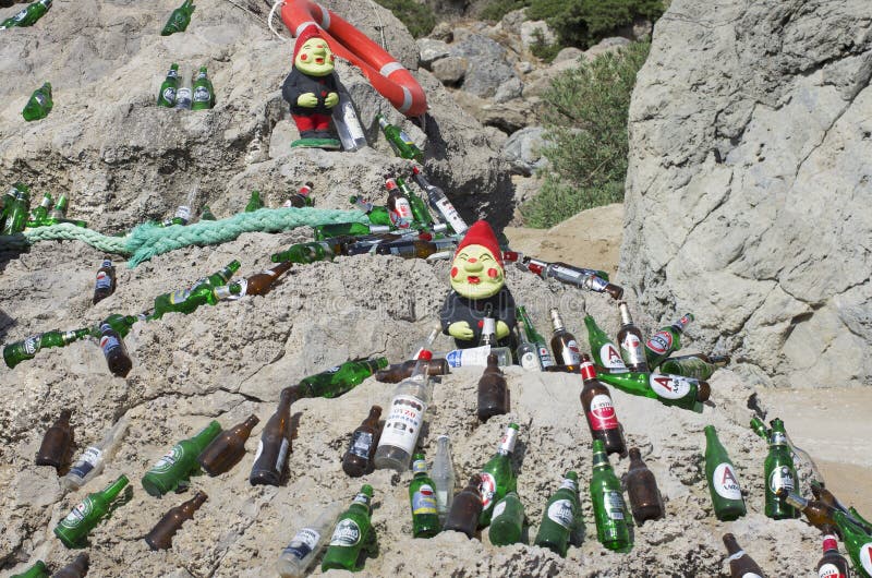 Beautifully laid out empty beer bottles on a huge boulder in a sunny weather.