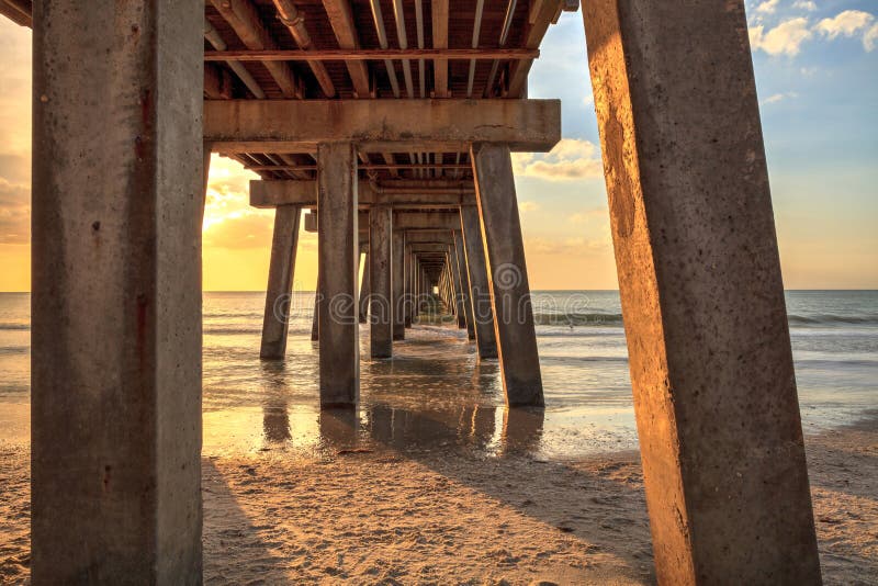 Under the Naples Pier with a Blue Sky Above in the Summer Stock Photo